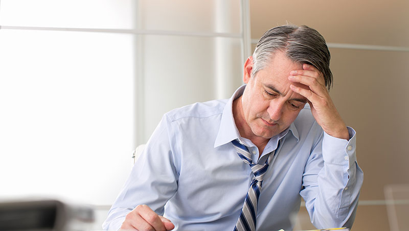 Man stressed at work in need of chiropractic care for stress relief