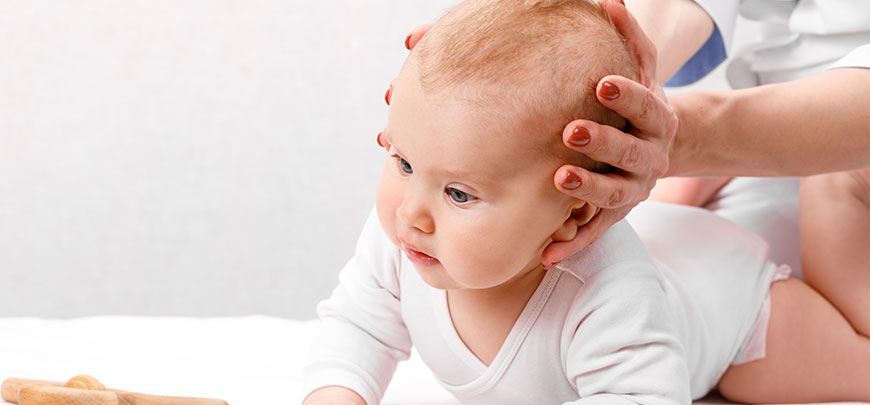 Infant recieving chiropractic adjustment for neck pain